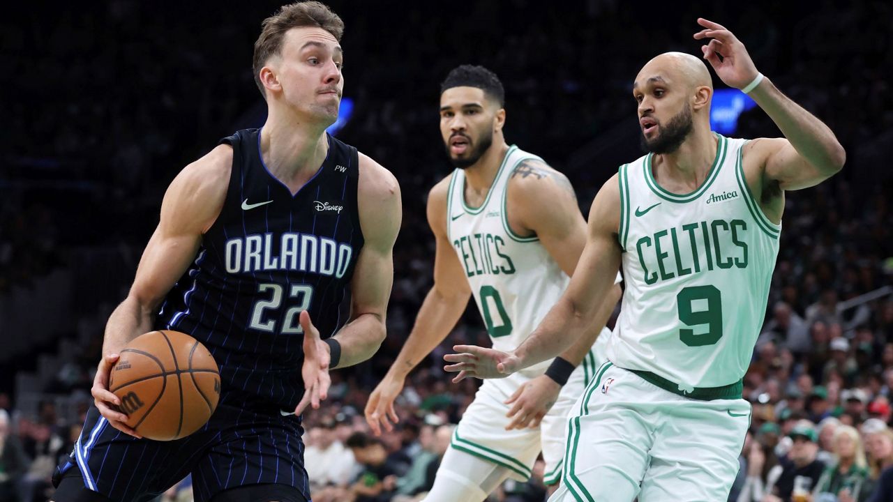Orlando Magic's Franz Wagner (22) drives past Boston Celtics' Derrick White (9) in front of Jayson Tatum (0) during the second half in Game 1 of a first-round NBA playoff basketball series Sunday, April 20, 2025, in Boston. (AP Photo/Michael Dwyer)