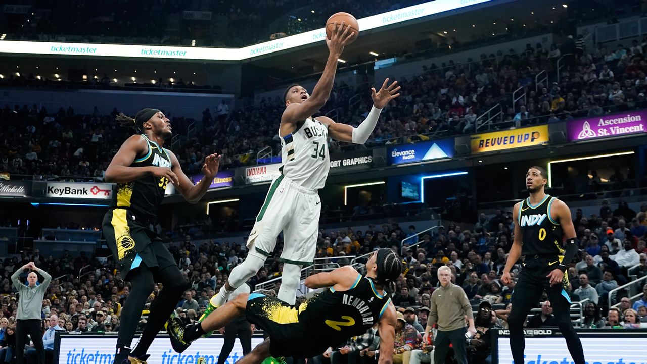 Indiana Pacers' Andrew Nembhard (2) defends as Milwaukee Bucks' Giannis Antetokounmpo (34) goes up for the basket during the second half of an NBA basketball game, Thursday, Nov. 9, 2023, in Indianapolis. Nembhard was called for a blocking foul on the play. (AP Photo/Darron Cummings)