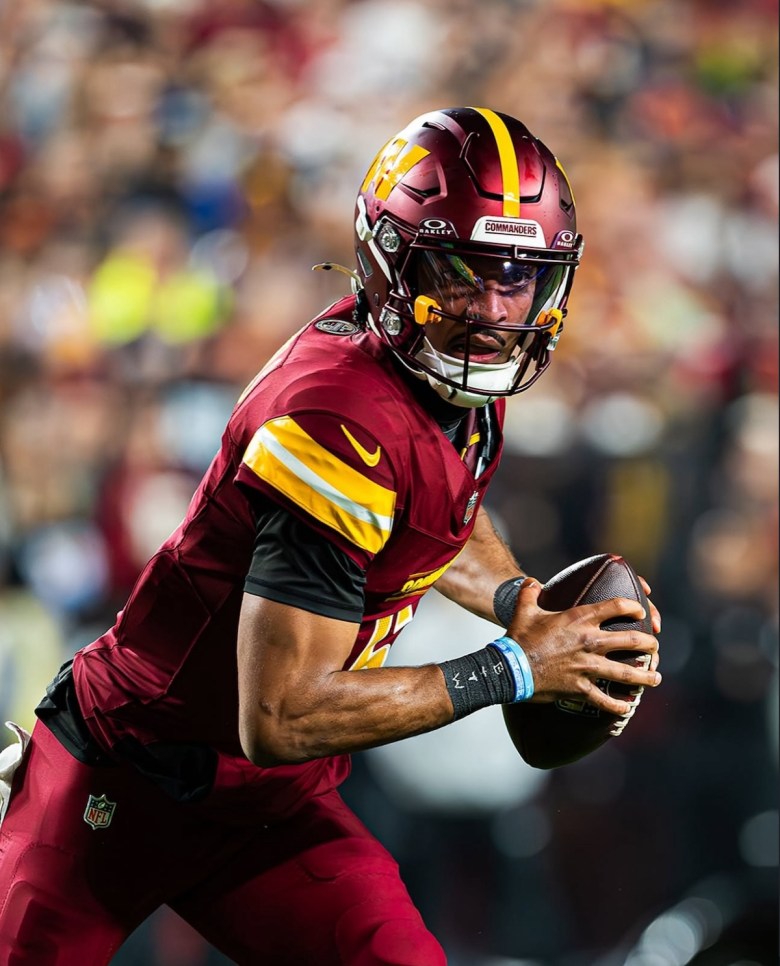 Jayden Daniels looks to make a play in the 30-24 overtime win against the Atlanta Falcons at Northwest Stadium in December 2024. (Abdullah Konte/The Washington Informer)