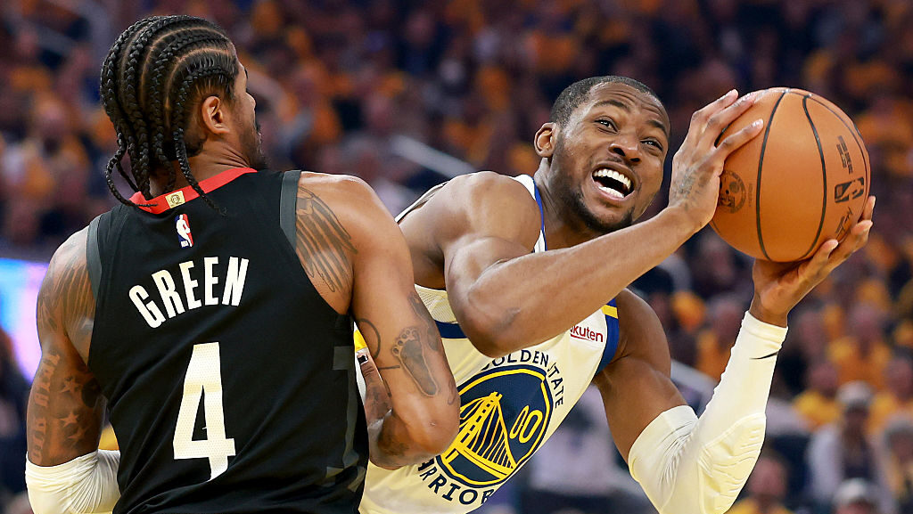 Jonathan Kuminga #00 of the Golden State Warriors makes a move towards the basket while defended by...