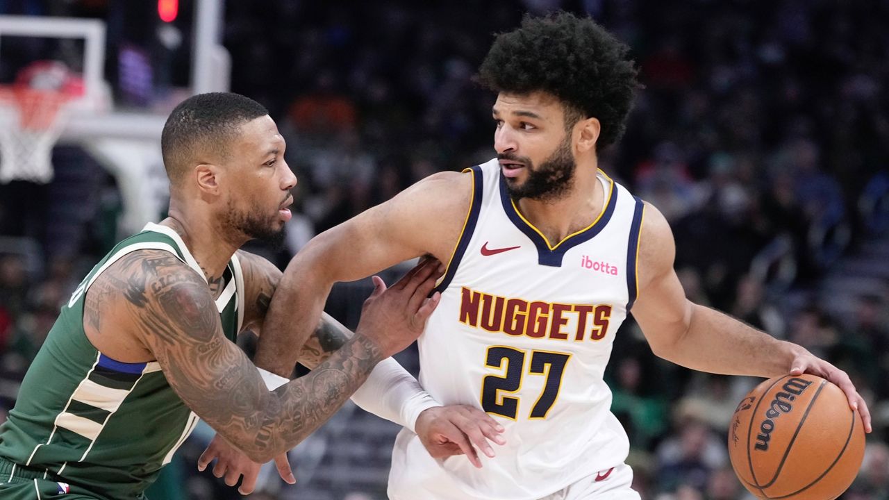 Denver Nuggets' Jamal Murray tries to get past Milwaukee Bucks' Damian Lillard during the first half of an NBA basketball game Thursday, Feb. 27, 2025, in Milwaukee.
