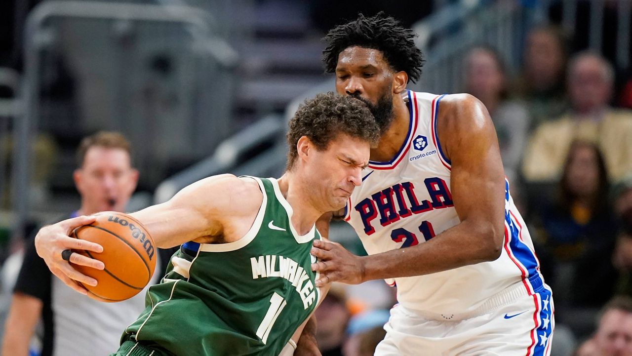 Milwaukee Bucks' Brook Lopez, left, drives against Philadelphia 76ers' Joel Embiid, right, during the first half of an NBA basketball game Sunday, Feb. 9, 2025, in Milwaukee. (AP Photo/Andy Manis)