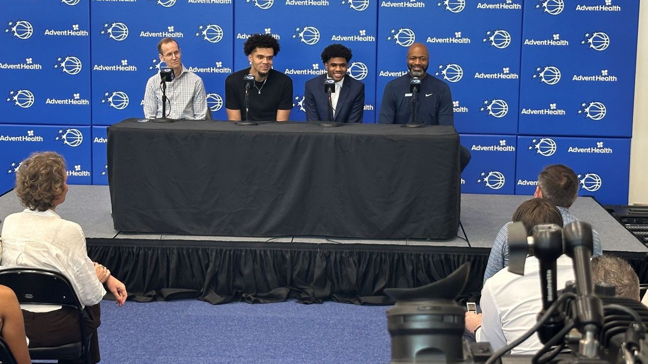 Magic President of Basketball Operations Jeff Weltman (left) and coach Jamahl Mosley (right) introduce new draft picks Noah Penda (2nd from left) and Jase Richardson to the Orlando media on Friday. (Spectrum Sports/Brandon Green)