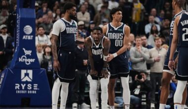Dallas Mavericks' Naji Marshall (13), left, and Max Christie (00) stand by Kyrie Irving (11), center, after Irving shot free throws after suffering an injury in the first half of an NBA basketball game against the Sacramento Kings in Dallas, Monday, March 3, 2025. (AP Photo/Tony Gutierrez)
