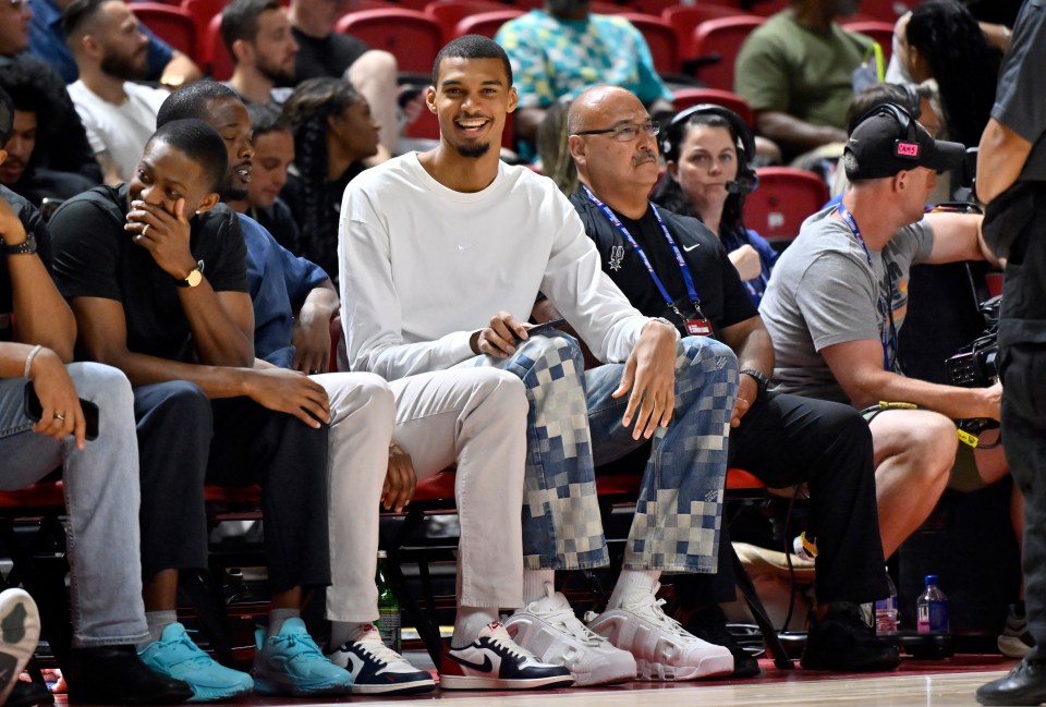 Victor Wembanyama sits courtside at an NBA Summer League game.