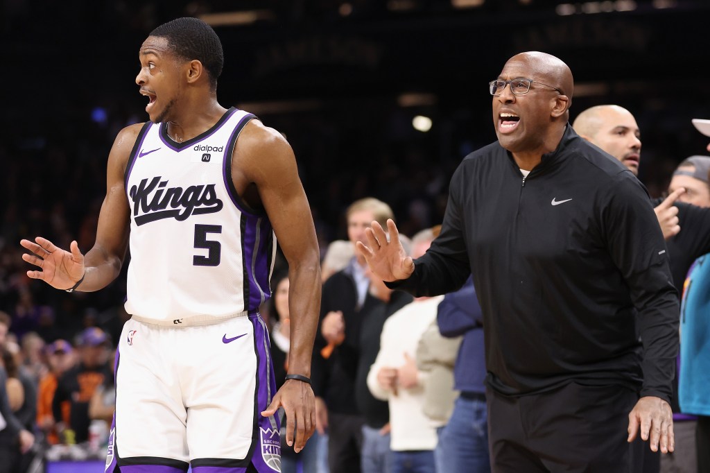De'Aaron Fox #5 of the Sacramento Kings and head coach Mike Brown react during a game.