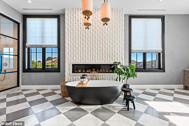 This bathroom - which is one of 12 in the property - boasts a sleek, black bathtub