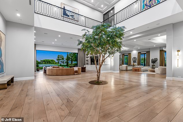 One foyer inside the stunning property has a tree planted in the center of the room