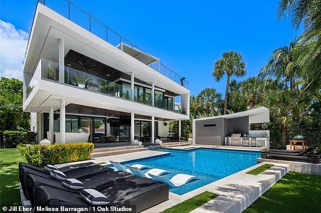Outside, the garden-level area features a pool with a waterfall and sun loungers