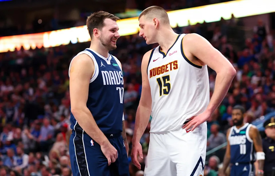 Dallas Mavericks guard Luka Doncic (77) speaks with Denver Nuggets center Nikola Jokic (15) during a game at American Airlines Center.