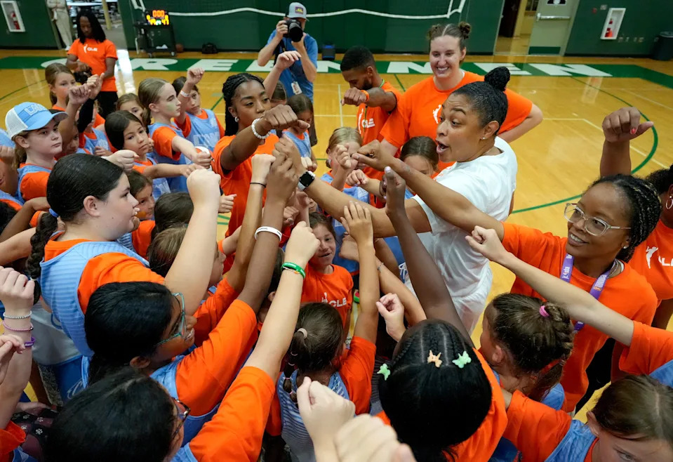 Jessica Davis, director of Youth Basketball Operations for the Cleveland Cavaliers, huddles with campers during a WNBA-themed girls basketball camp held at Aurora High School on July 31.