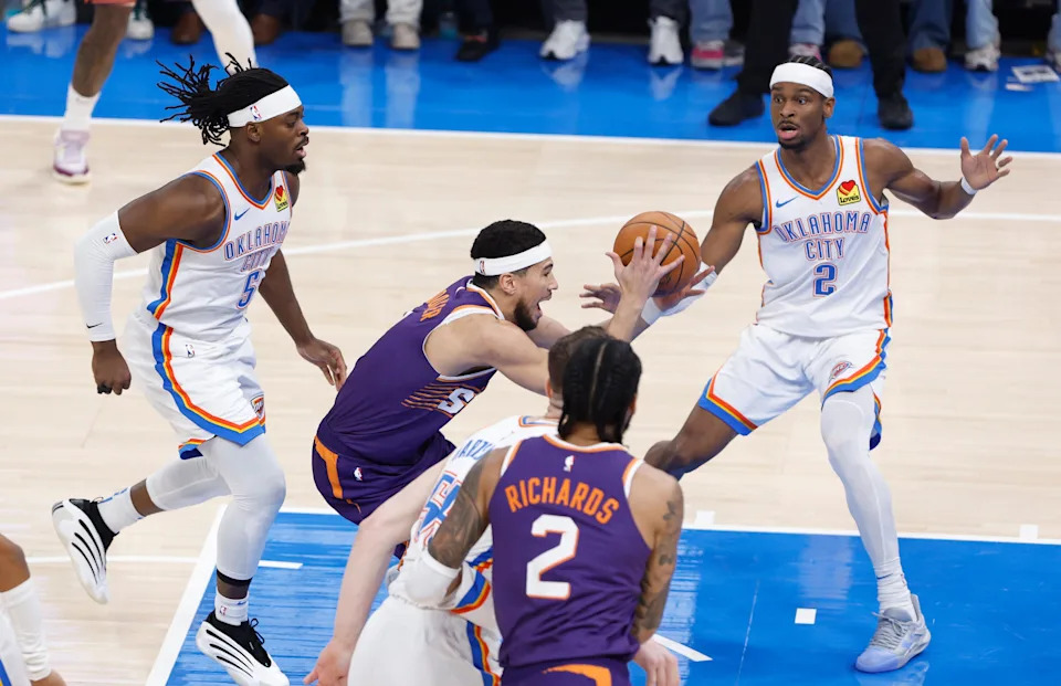 Feb 5, 2025; Oklahoma City, Oklahoma, USA; Phoenix Suns guard Devin Booker (1) drives to the basket between Oklahoma City Thunder guard Luguentz Dort (5), guard Shai Gilgeous-Alexander (2) and center Isaiah Hartenstein (55) during the first quarter of a game at Paycom Center. Mandatory Credit: Alonzo Adams-Imagn Images
