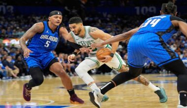 Boston Celtics forward Jayson Tatum, center, drives between Orlando Magic forward Paolo Banchero (5) and center Wendell Carter Jr. (34) during the first half in Game 4 of a first-round NBA basketball playoff series, Sunday, April 27, 2025, in Orlando, Fla. (AP Photo/John Raoux)