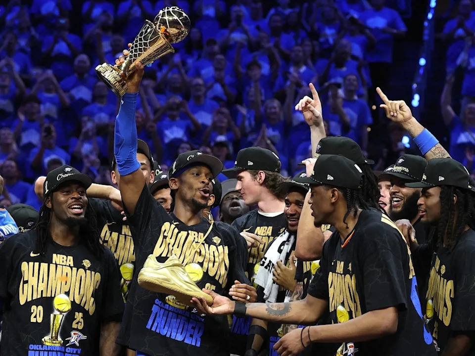 Shai Gilgeous-Alexander of the Oklahoma City Thunder celebrates with the Bill Russell NBA Finals Most Valuable Player trophy.