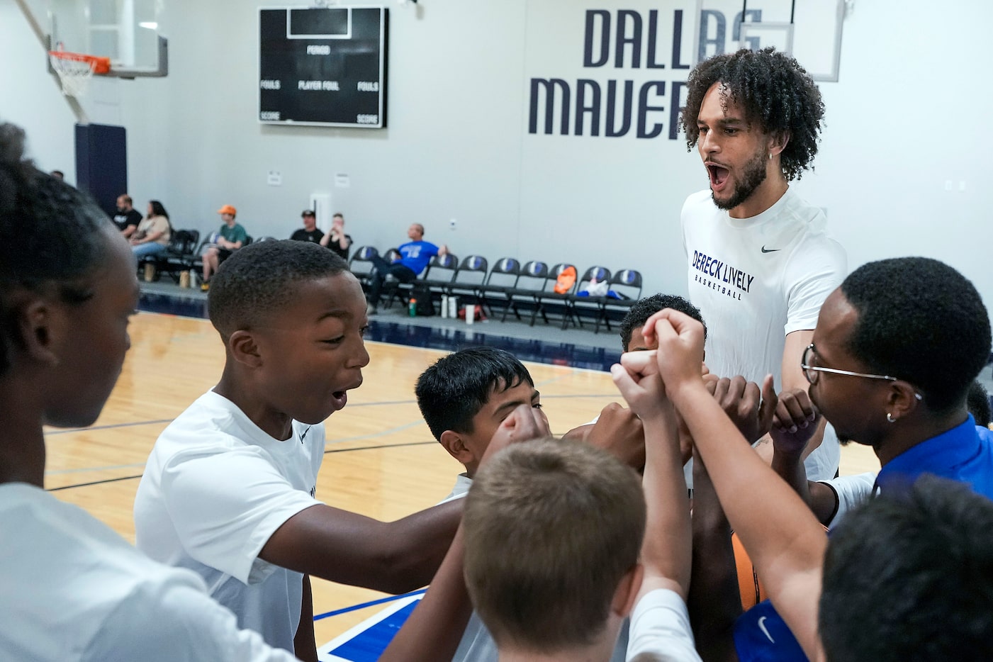 Dallas Mavericks center Dereck Lively II huddles with participants during a Mavs Academy...