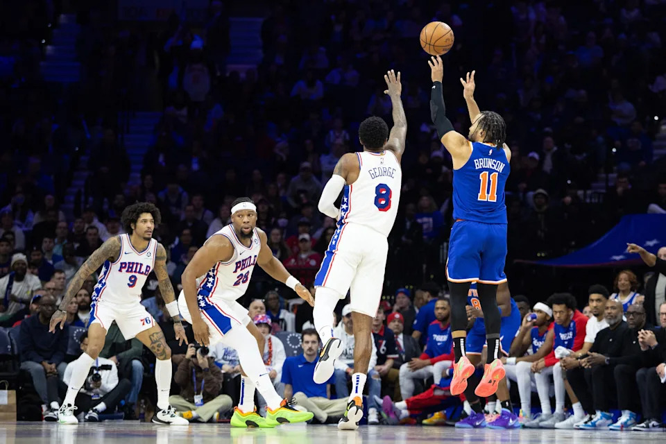 Jan 15, 2025; Philadelphia, Pennsylvania, USA; New York Knicks guard Jalen Brunson (11) scores a three pointer in front of Philadelphia 76ers forward Paul George (8) in overtime at Wells Fargo Center. Mandatory Credit: Bill Streicher-Imagn Images