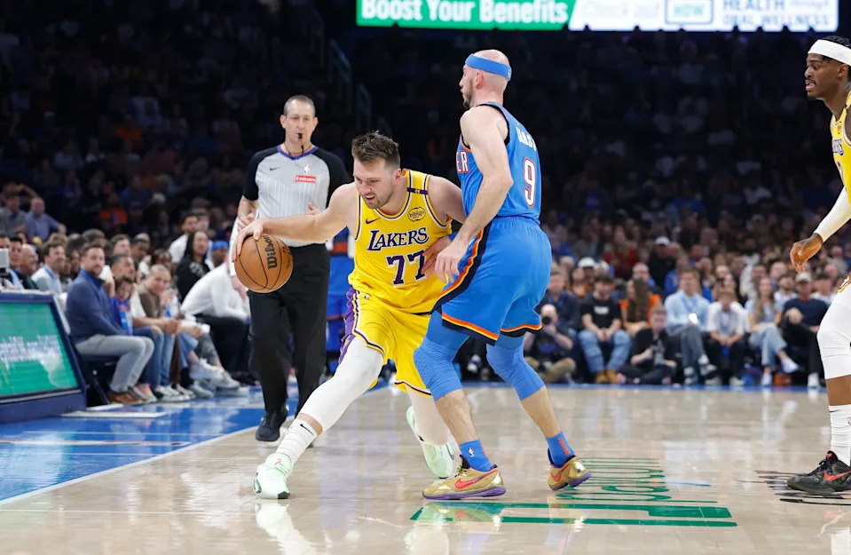Apr 8, 2025; Oklahoma City, Oklahoma, USA; Los Angeles Lakers guard Luka Doncic (77) moves the ball down the court against Oklahoma City Thunder guard Alex Caruso (9) during the second quarter at Paycom Center. Mandatory Credit: Alonzo Adams-Imagn Images