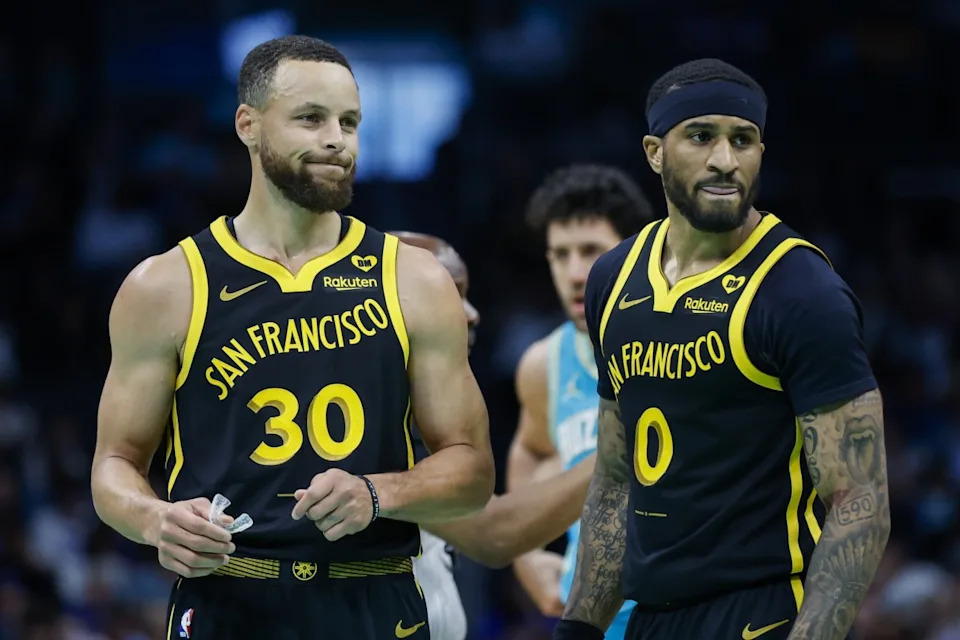 Golden State Warriors guards Stephen Curry and Gary Payton II look to the bench.© Nell Redmond-Imagn Images