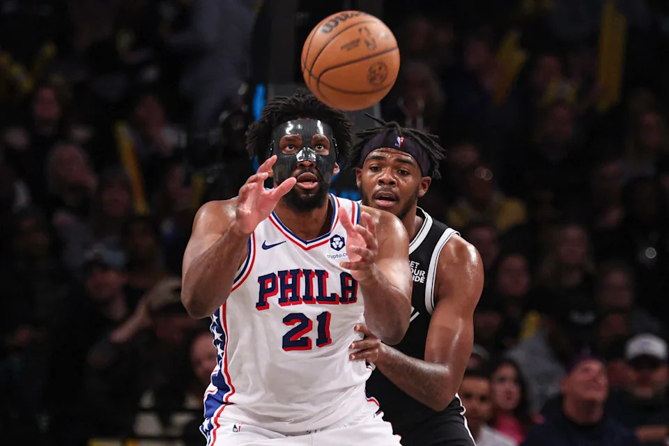 Jan 4, 2025; Brooklyn, New York, USA; Philadelphia 76ers center Joel Embiid (21) catches a pass during the second half as Brooklyn Nets forward Maxwell Lewis (20) defends at Barclays Center. Mandatory Credit: Vincent Carchietta-Imagn Images