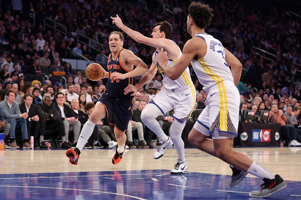 Feb 29, 2024; New York, New York, USA; New York Knicks forward Bojan Bogdanovic (44) drives to the basket against Golden State Warriors forwards Dario Saric (20) and Trayce Jackson-Davis (32) during the second quarter at Madison Square Garden. Mandatory Credit: Brad Penner-USA TODAY Sports