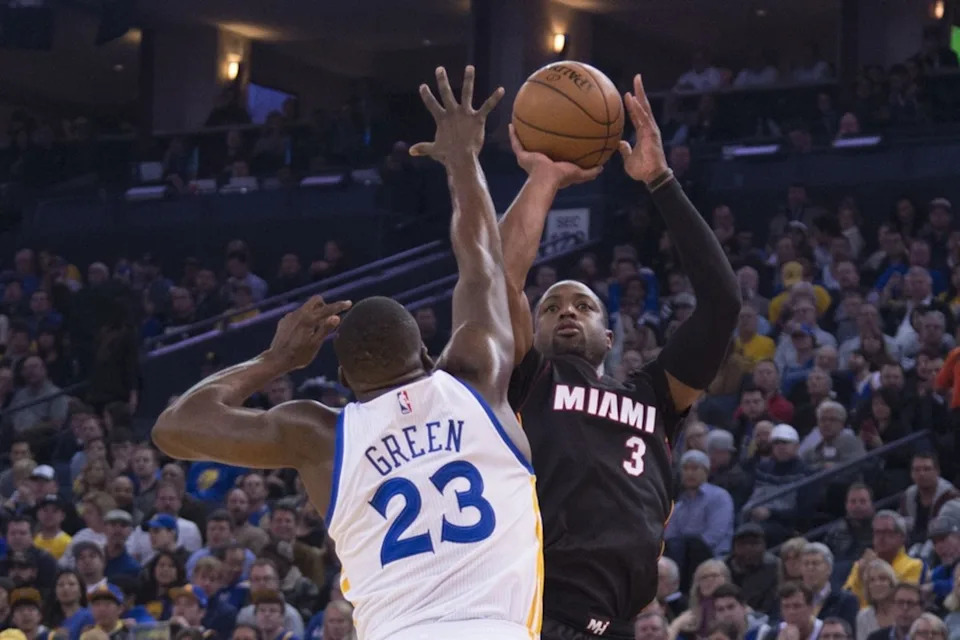 Miami Heat guard Dwyane Wade shoots the basketball against Golden State Warriors forward Draymond Green.© Kyle Terada-Imagn Images