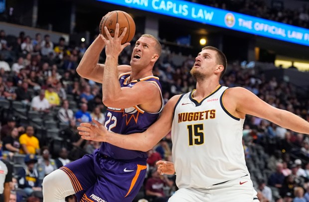 Phoenix Suns center Mason Plumlee, left, drives to the rim past Denver Nuggets center Nikola Jokic in the second half of an NBA preseason game Sunday, Oct. 13, 2024, in Denver. (AP Photo/David Zalubowski)