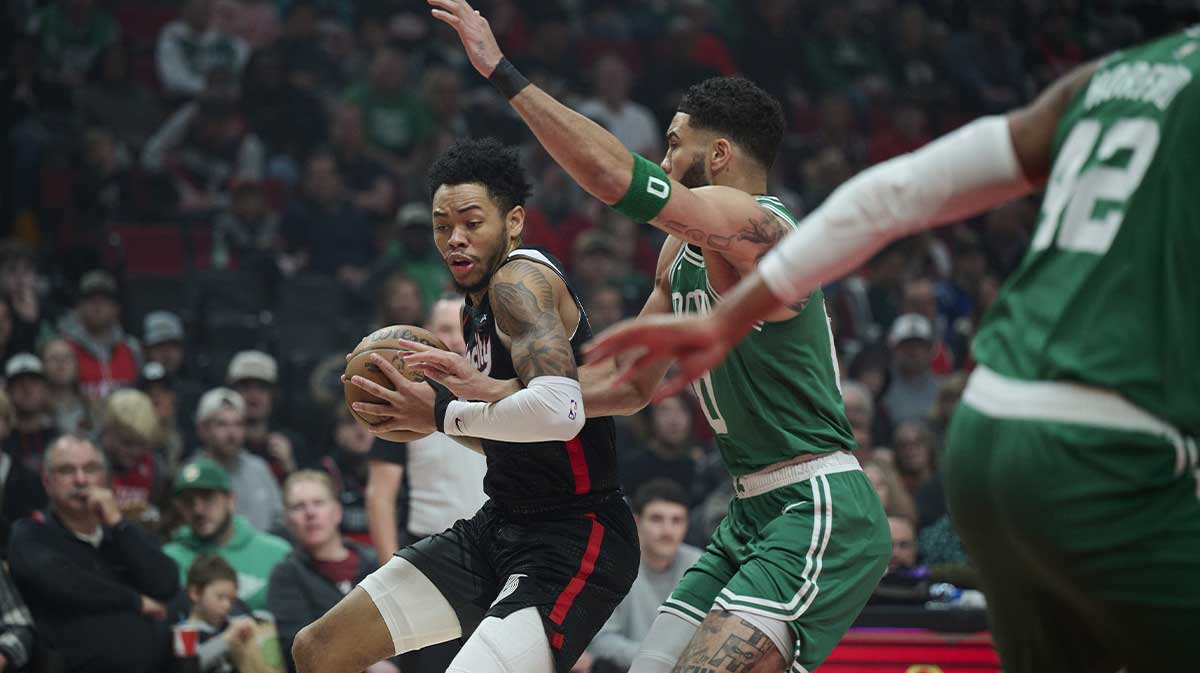 Portland Trail Blazers guard Anfernee Simons (1) dribbles the ball during the first half against Boston Celtics forward Jayson Tatum (0) at Moda Center.