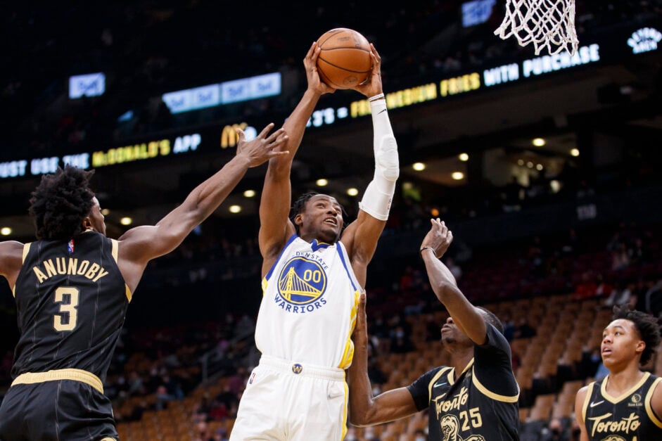 Jonathan Kuminga #00 of the Golden State Warriors drives to the net against OG Anunoby #3 and Chris Boucher #25 of the Toronto Raptors during the first half of their NBA game at Scotiabank Arena on December 18, 2021 in Toronto, Canada.