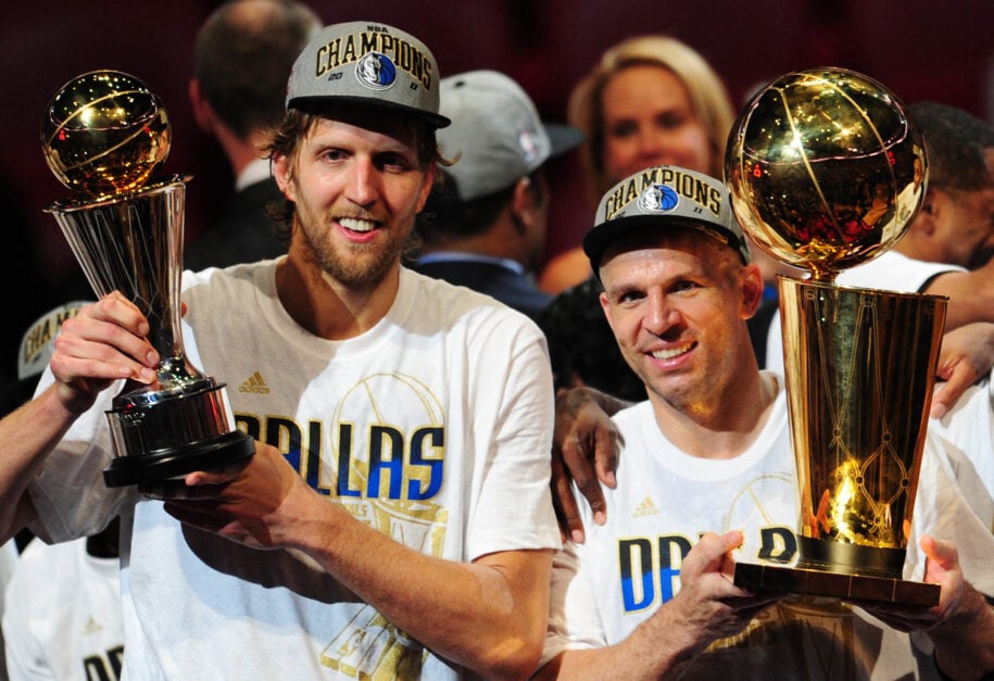 Dirk Nowitzki (L) and Jason Kidd (R) of the Dallas Mavericks hold the MVP and Larry O'Brien Trophies after defeating the Miami Heat
