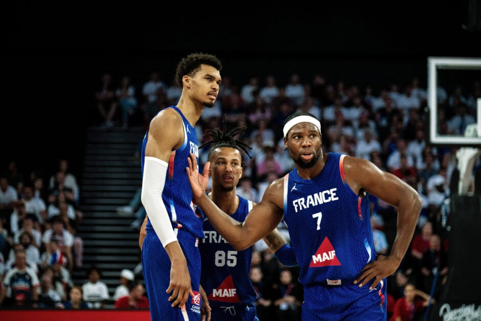 France's center Victor Wembanyama #32 (L), France's guard Matthew Strazel #85 (C) and France's forward Guerschon Yabusele #7 (R) react during the exhibition game between France and Serbia ahead of the Paris 2024 Olympic Games, in the LDLC Arena in Decines-Charpieu, eastern France, on July 12, 2024.