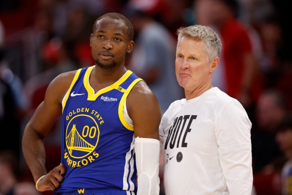 Jonathan Kuminga #00 of the Golden State Warriors and head coach Steve Kerr stand on the sideline in overtime against the Houston Rockets at Toyota Center on November 02, 2024 in Houston, Texas.