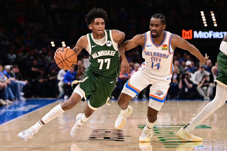 AJ Johnson #77 of the Milwaukee Bucks handles the ball in front of Adam Flagler #14 of the Oklahoma City Thunder during the second half at Paycom Center on February 3, 2025 in Oklahoma City, Oklahoma.