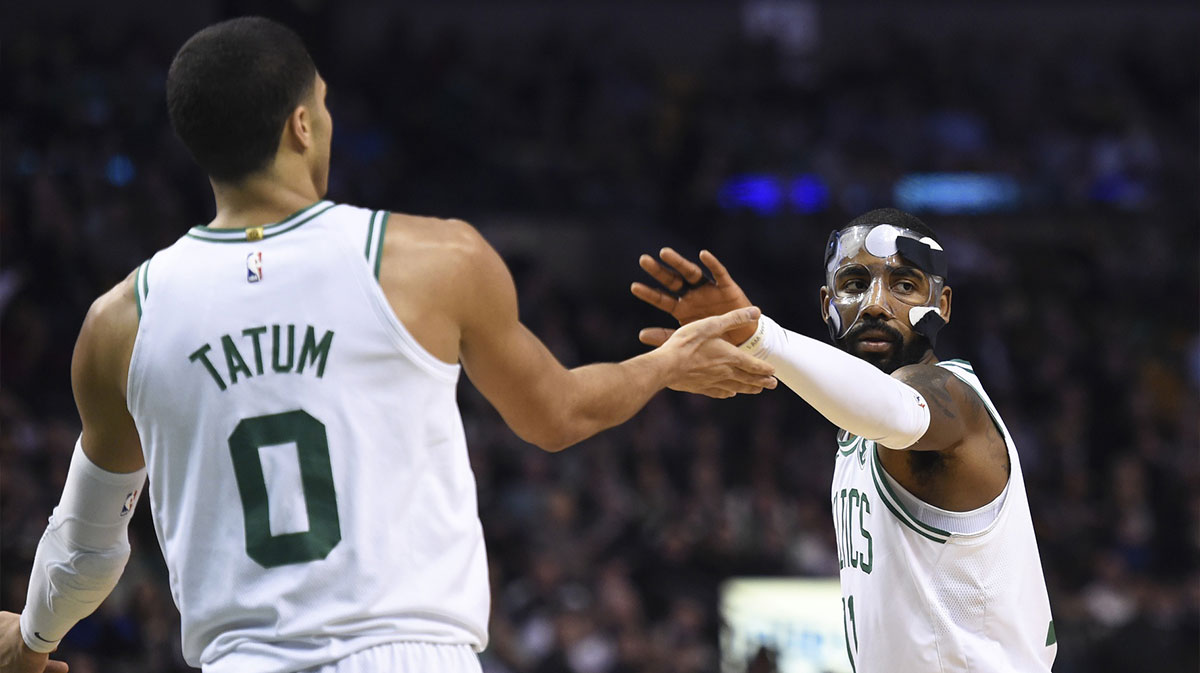 Boston Celtics guard Kyrie Irving (11) celebrates with forward Jayson Tatum (0) after scoring during the first half against the Philadelphia 76ers at TD Garden.