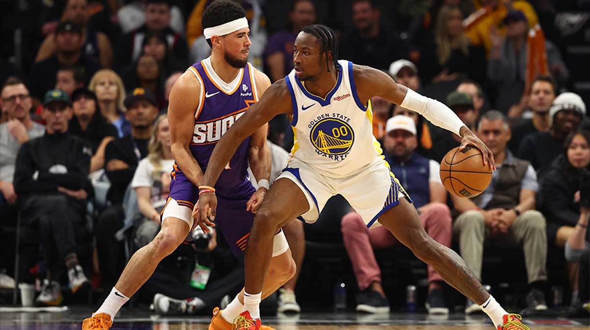 Golden State Warriors forward Jonathan Kuminga (00) against Phoenix Suns guard Devin Booker (1) at Footprint Center.