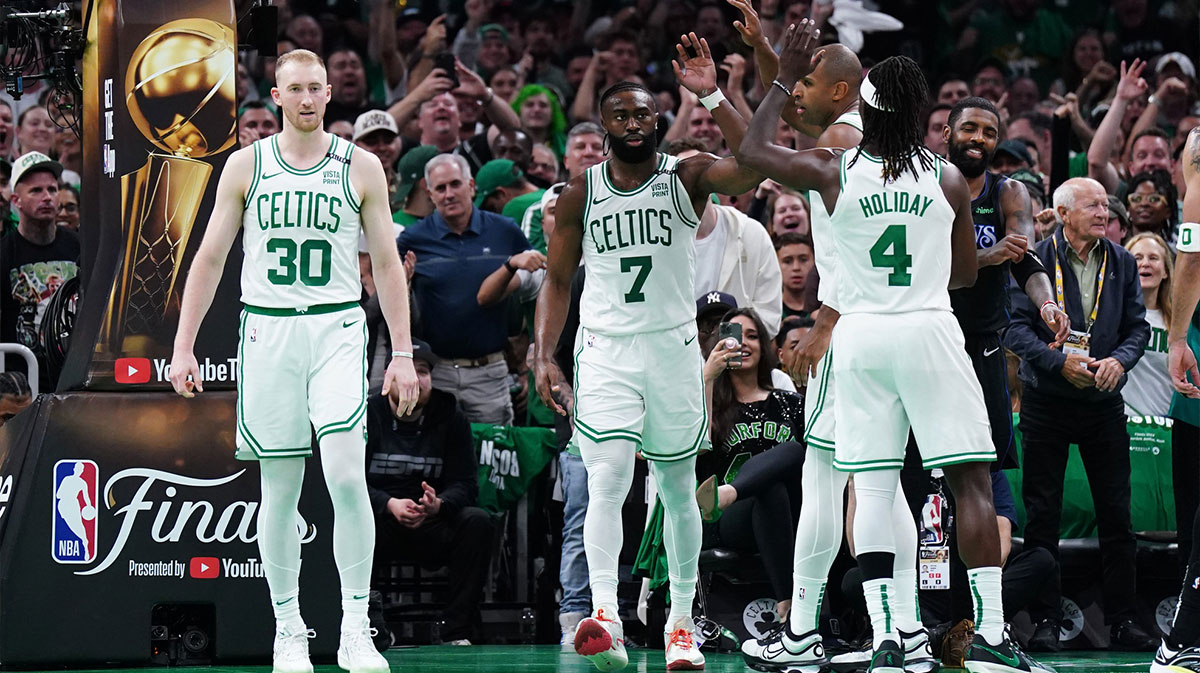 Boston Celtics guard Jaylen Brown (7) and center Al Horford (42) and guard Jrue Holiday (4) react in the third quarter against the Dallas Mavericks during game one of the 2024 NBA Finals at TD Garden.