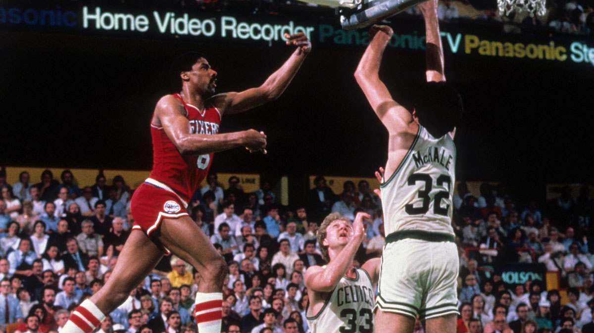 Philadelphia 76ers forward Julius Erving (6) takes a shot against Boston Celtics forward Larry Bird (33) and Kevin McHale (32) at the Boston Garden.