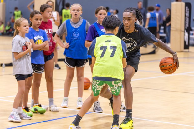 Lowell native and Brooklyn Nets guard Terance Mann, right, took the floor with a young camper as other campers looked on at The Mill Works in Westford on Wednesday during his Complete Player Foundation event. (James Thomas for the Lowell Sun)