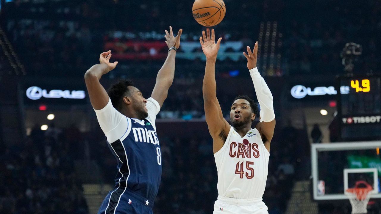 Cleveland Cavaliers guard Donovan Mitchell (45) shoots a 3-point basket over Dallas Mavericks forward Olivier-Maxence Prosper (8) in the first half of an NBA basketball game, Sunday, Feb. 2, 2025, in Cleveland. (AP Photo/Sue Ogrocki)