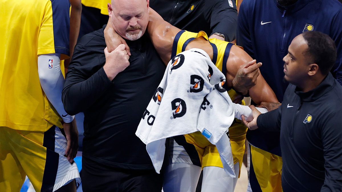 Pacers guard Tyrese Haliburton (0) is assisted after an apparent injury following a play against the Oklahoma City Thunder during the first half of game seven of the 2025 NBA Finals at Paycom Center