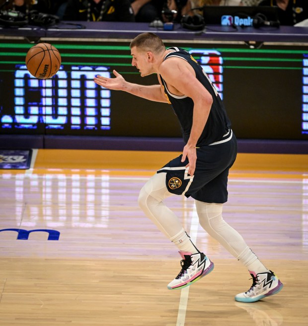 Nikola Jokic (15) of the Denver Nuggets ducks as he searches for an overhead pass before regaining his wit before tapping it to Michael Porter Jr. (1) for an assist against the Los Angeles Lakers during the second half of the Lakers' 119-108 win at Crypto.com Arena in Los Angeles on Saturday, April 27, 2024. (Photo by AAron Ontiveroz/The Denver Post)