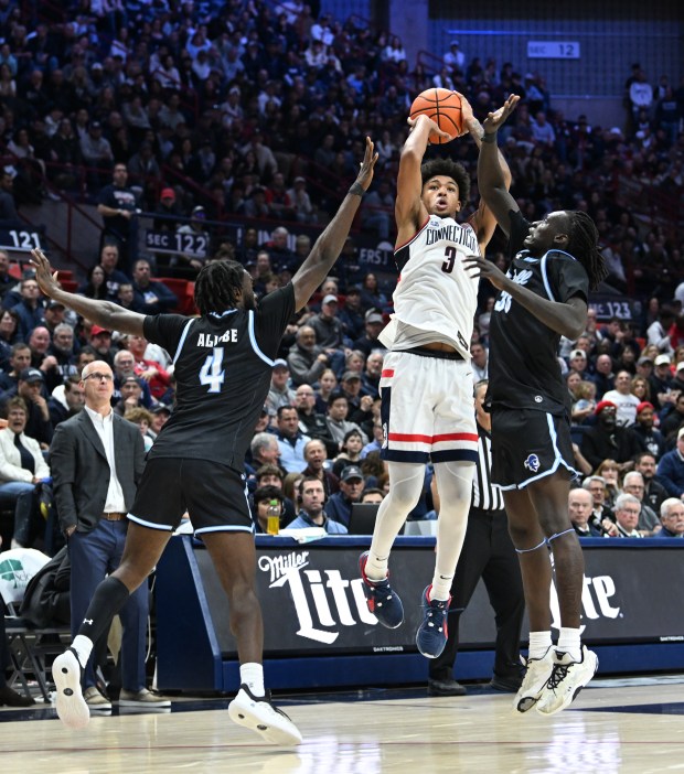 Connecticut Huskies forward Jaylin Stewart (3) shoots a jumper between Seton Hall Pirates forward Prince Aligbe (4) and Seton Hall Pirates guard Garwey Dual (33) in the second half of a Big East matchup at Gampel Pavilion, Storrs, Conn., March 8, 2025. UConn won, 81-50. Photo by Cloe Poisson/Special to the Courant