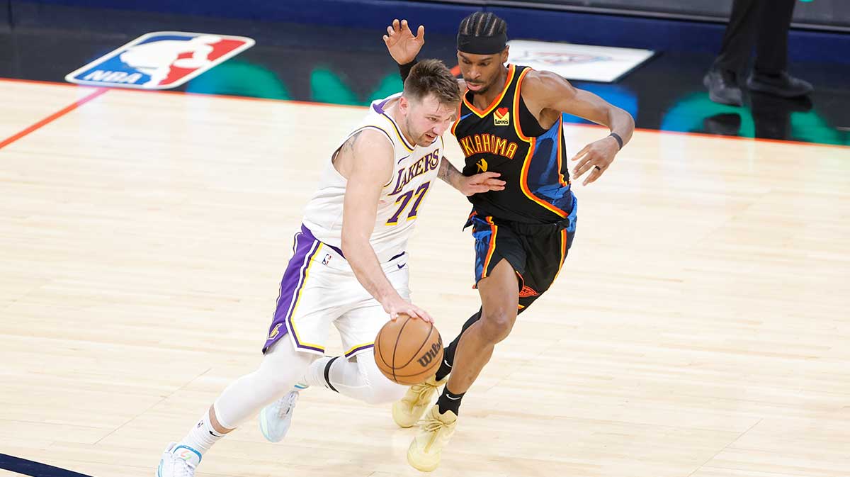 Lakers guard Luka Doncic (77) drives down the court beside Oklahoma City Thunder guard Shai Gilgeous-Alexander (2) during the second half at Paycom Center