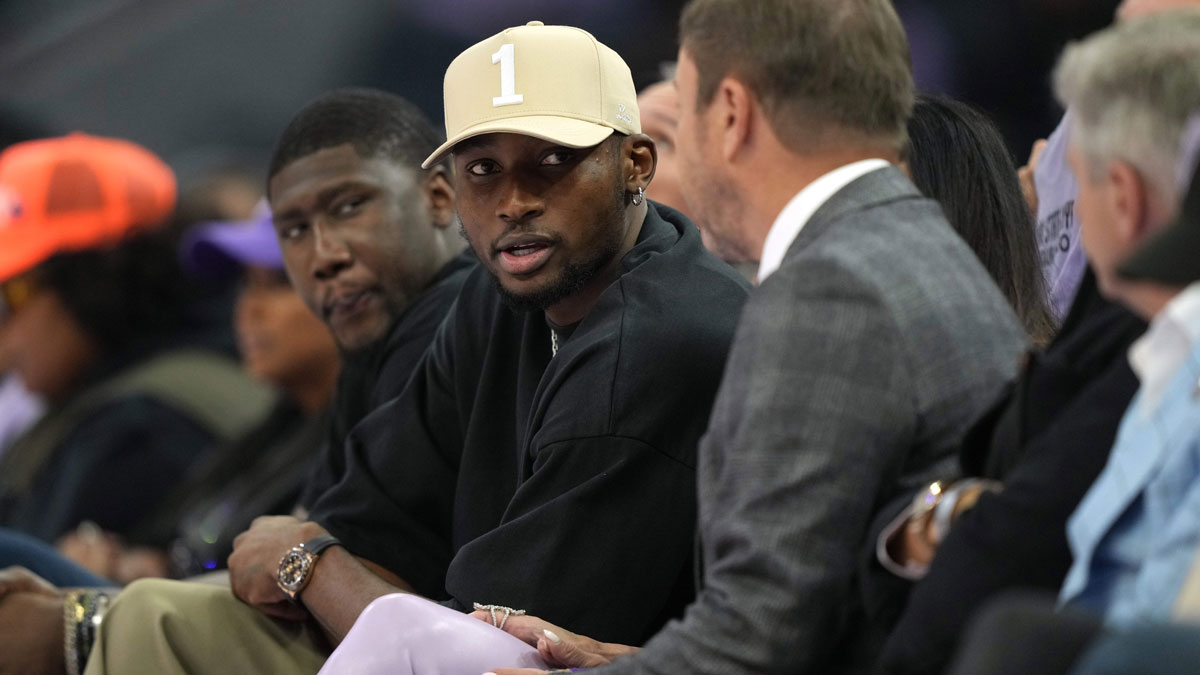 Warriors forward Jonathan Kuminga (center left) talks with owner Joe Lacob (center right) during the second quarter of the game between the Golden State Valkyries and the Los Angeles Sparks at Chase Center