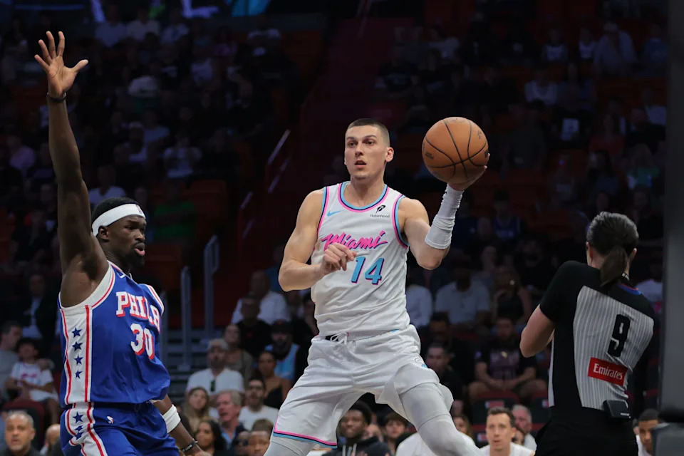 Apr 7, 2025; Miami, Florida, USA; Miami Heat guard Tyler Herro (14) passes the basketball as Philadelphia 76ers center Adem Bona (30) defends during the first quarter at Kaseya Center. Mandatory Credit: Sam Navarro-Imagn Images