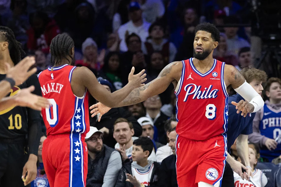 Philadelphia 76ers forward Paul George high-fives guard Tyrese Maxey.© Bill Streicher-Imagn Images