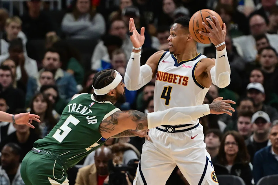 Denver Nuggets guard Russell Westbrook looks to pass the ball away from Milwaukee Bucks guard Gary Trent Jr.© Benny Sieu-Imagn Images