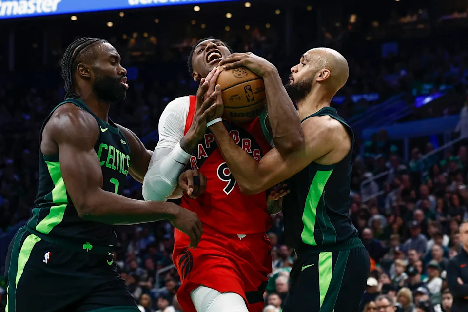 BOSTON, MA - NOVEMBER 16: RJ Barrett #9 of the Toronto Raptors gets tied up going to the basket by Derrick White #9 of the Boston Celtics, right, and Jaylen Brown #7 during the third quarter at TD Garden on November 16, 2024 in Boston, Massachusetts. NOTE TO USER: User expressly acknowledges and agrees that, by downloading and/or using this Photograph, user is consenting to the terms and conditions of the Getty Images License Agreement. (Photo By Winslow Townson/Getty Images)