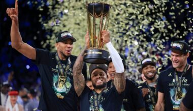 Milwaukee Bucks guard Damian Lillard (0) lifts up the NBA Cup while forward Giannis Antetokounmpo (34), left, and center Brook Lopez (11), right, celebrate after their team's victory in the championship game of the NBA Cup basketball tournament