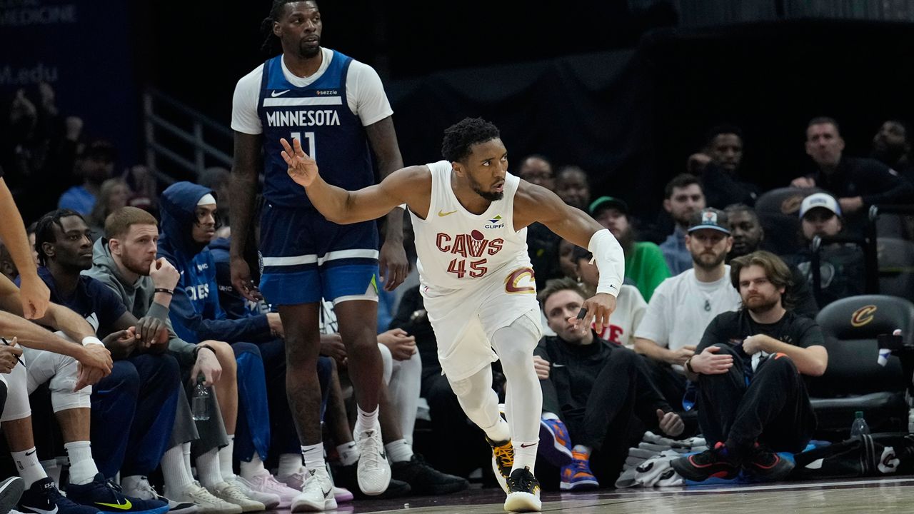 Cleveland Cavaliers guard Donovan Mitchell (45) gestures in front of Minnesota Timberwolves center Naz Reid (11) after hitting a 3-point basket in the first half of an NBA basketball game Monday, Feb. 10, 2025, in Cleveland. (AP Photo/Sue Ogrocki)