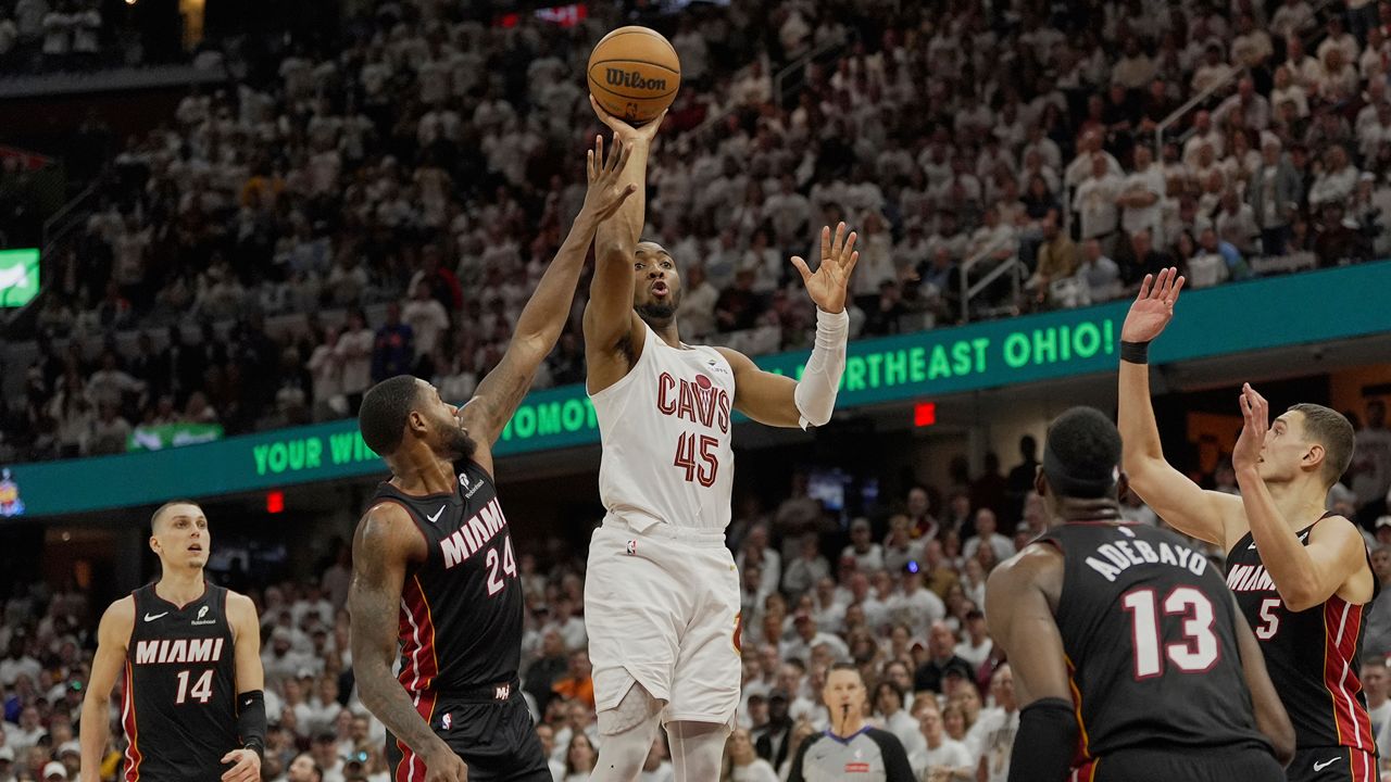 Cleveland Cavaliers guard Donovan Mitchell (45) shoots between Miami Heat's Tyler Herro (14), Haywood Highsmith (24), Bam Adebayo (13) and Nikola Jovic (5) in the second half in Game 2 of an NBA first-round playoff series, Wednesday, April 23, 2025, in Cleveland. (AP Photo/Sue Ogrocki)